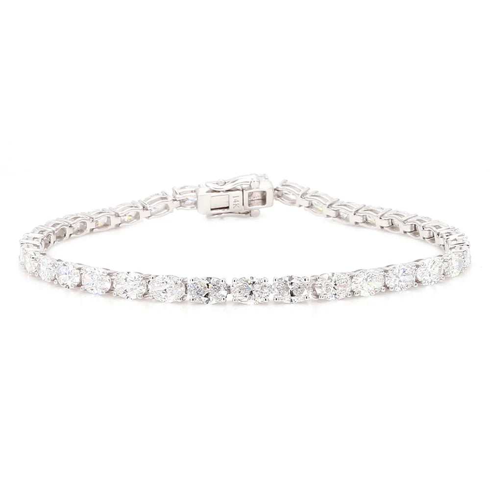 A silver tennis bracelet with a row of round-cut clear gemstones and a clasp closure, shown on a plain white background.
