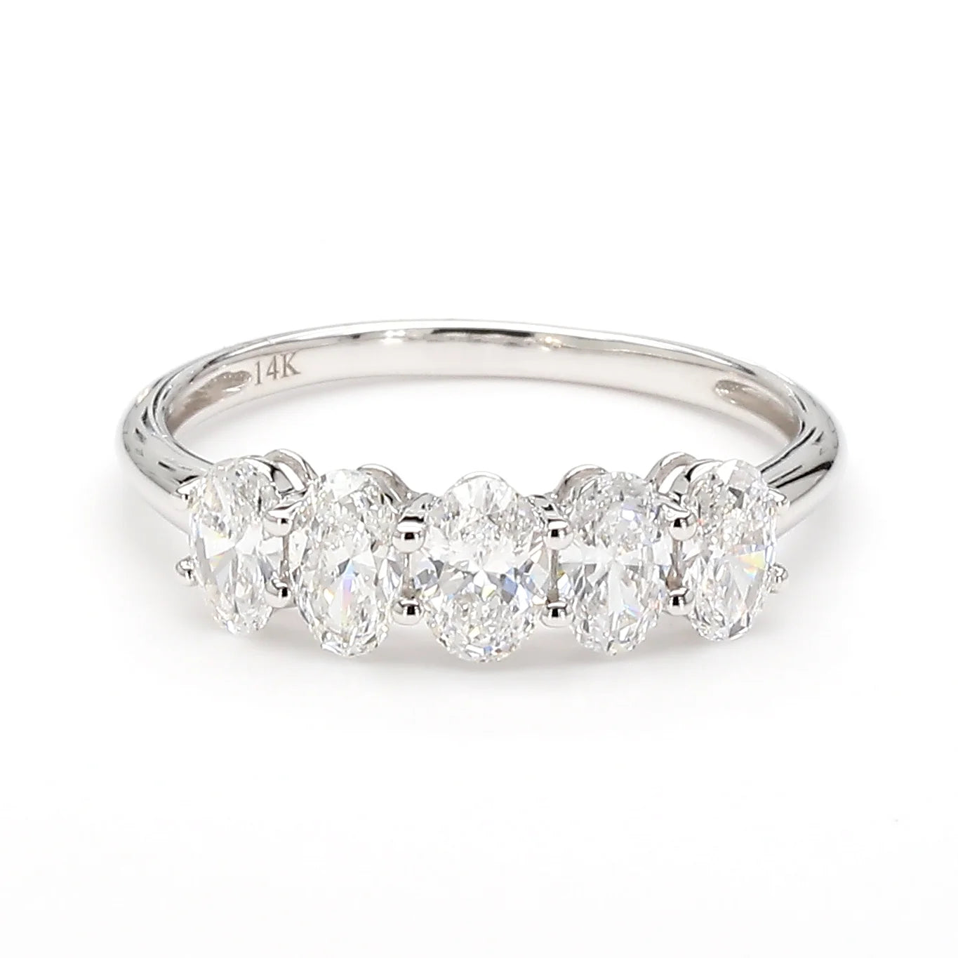 A five-stone diamond ring in a polished silver-colored metal band, featuring five oval-cut diamonds set in a row. The inside of the band is marked '14K', indicating the gold content.