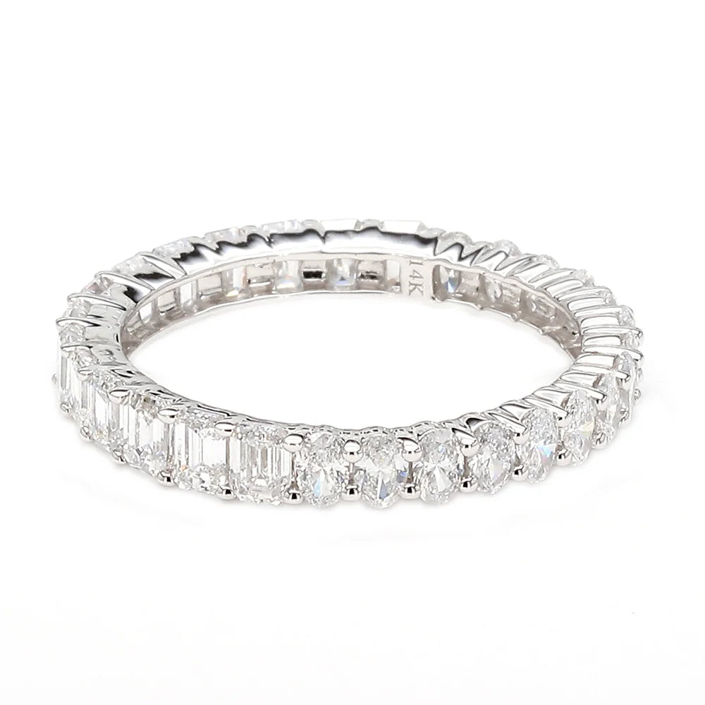 A silver-toned eternity ring featuring a continuous row of baguette and round-cut clear gemstones, photographed on a seamless white background.