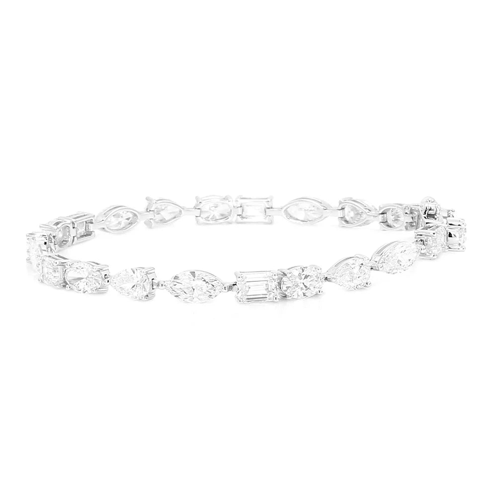 A silver tennis bracelet featuring a continuous link design with various clear gemstones in marquise, emerald, round, and baguette shapes, displayed on a solid white background.