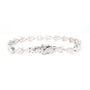 A silver tennis bracelet featuring a continuous link design with pear-cut and heart-shaped clear gemstones, displayed on a solid white background.