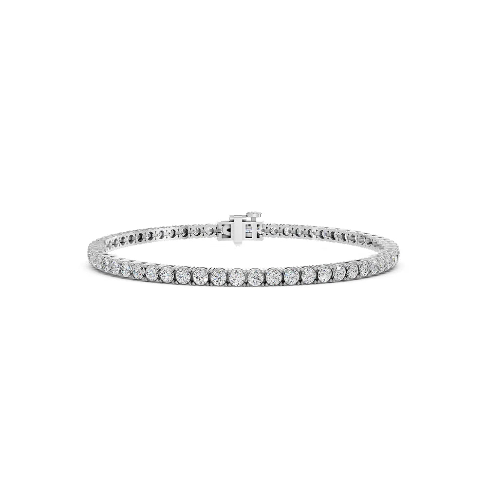 A silver tennis bracelet with a continuous row of round-cut clear gemstones and a small clasp, shown on a plain white background.