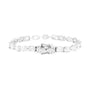A silver tennis bracelet featuring a central cluster of baguette and round-cut clear stones, photographed on a solid white background.