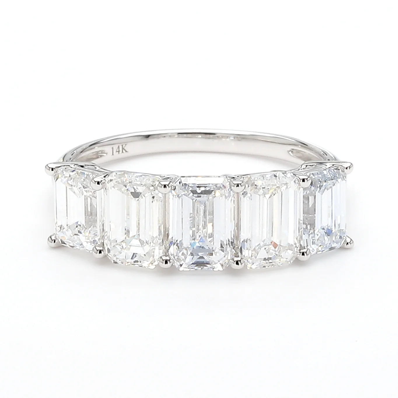 A silver band ring featuring a row of baguette-cut clear gemstones, photographed on a clean white background.
