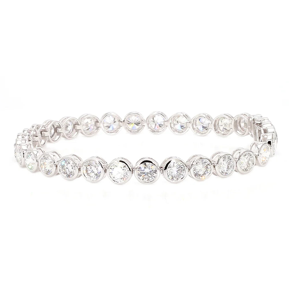 A silver tennis bracelet featuring round-cut clear gemstones in a continuous row, set in a polished silver-tone metal, shown against a plain white background.