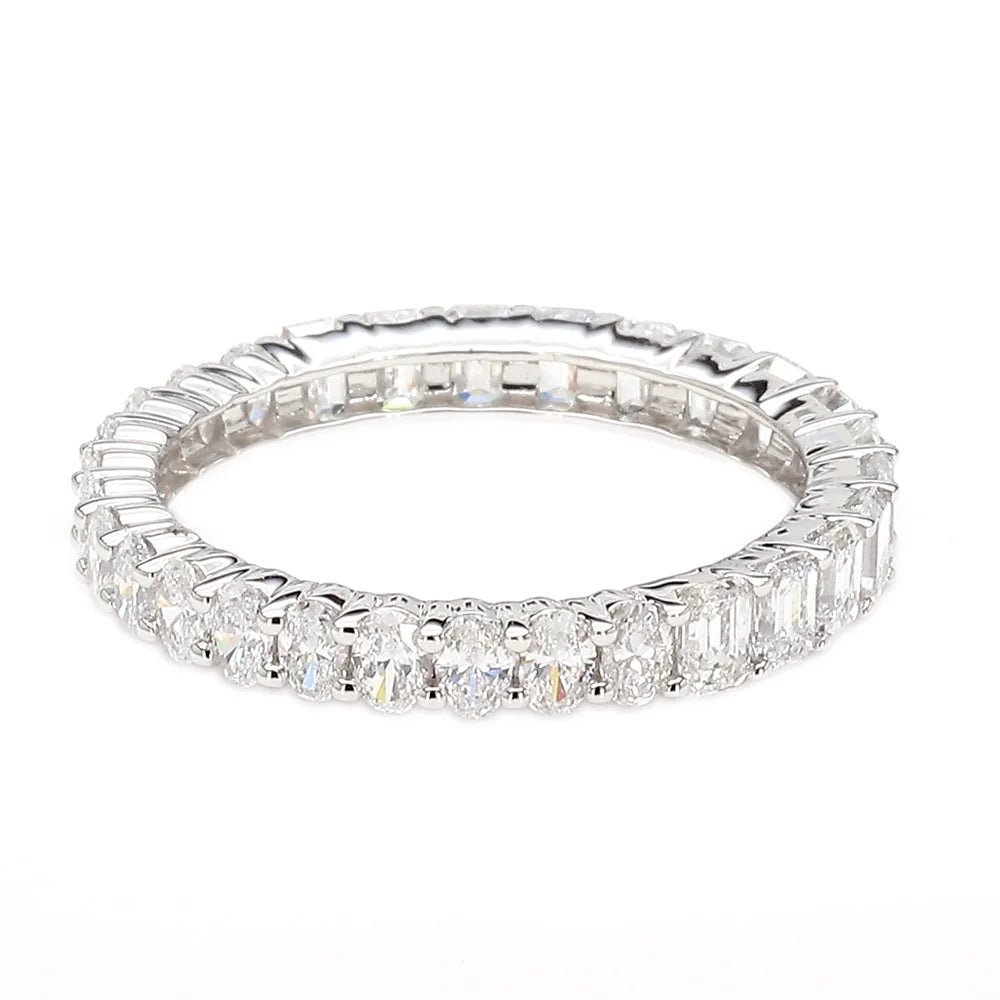 A silver-toned eternity ring featuring a continuous row of baguette and round-cut clear gemstones, shown on a plain white background.