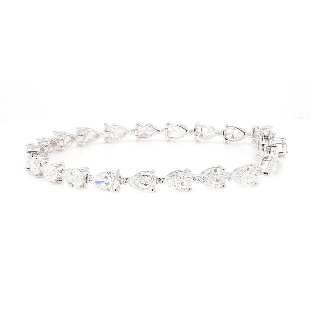 A silver tennis bracelet featuring a continuous line of clear pear-cut and round-cut gemstones on a white background.