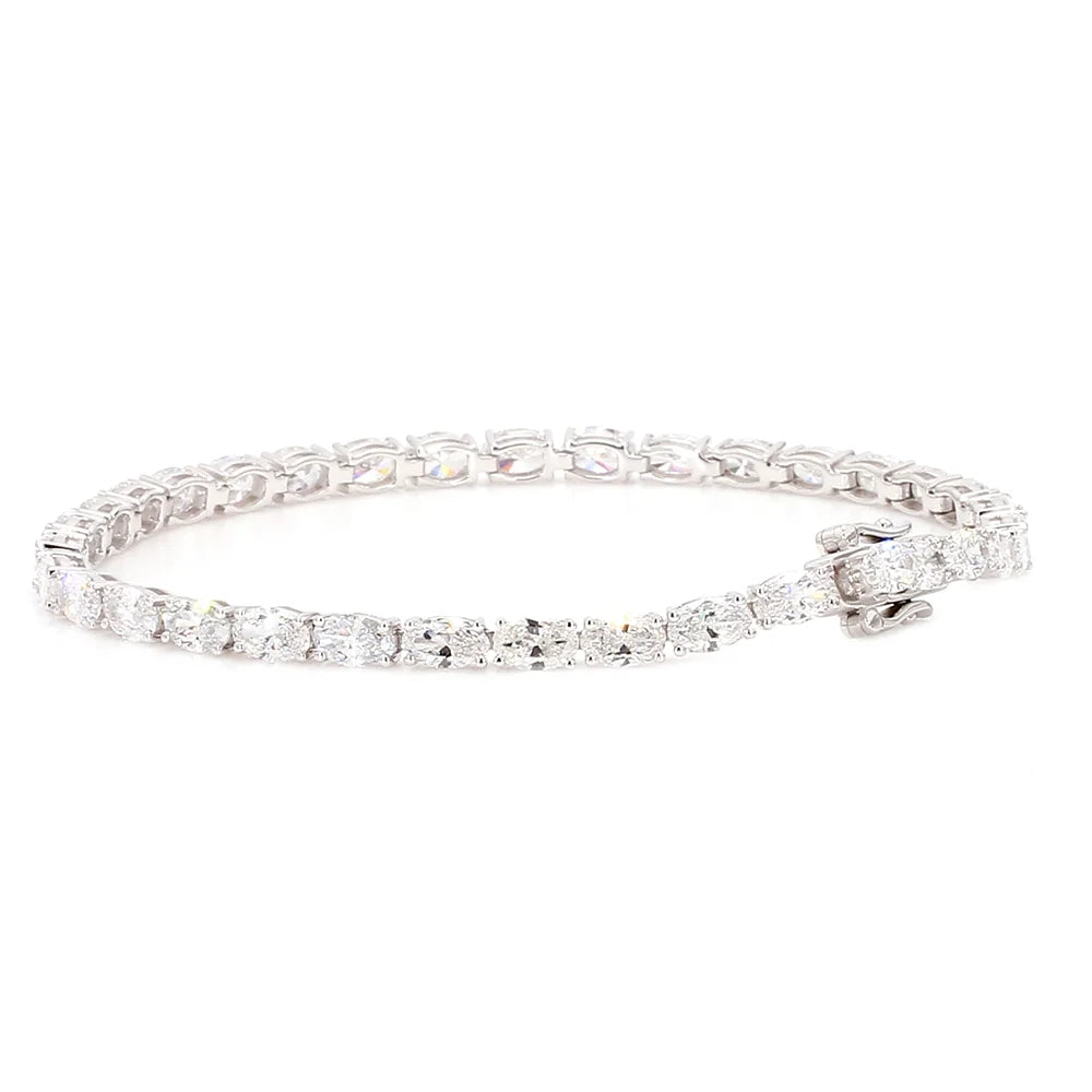 A diamond tennis bracelet with a brilliant link design and a small matching diamond accent on the clasp, set in a silver-colored metal, shown against a plain white background.