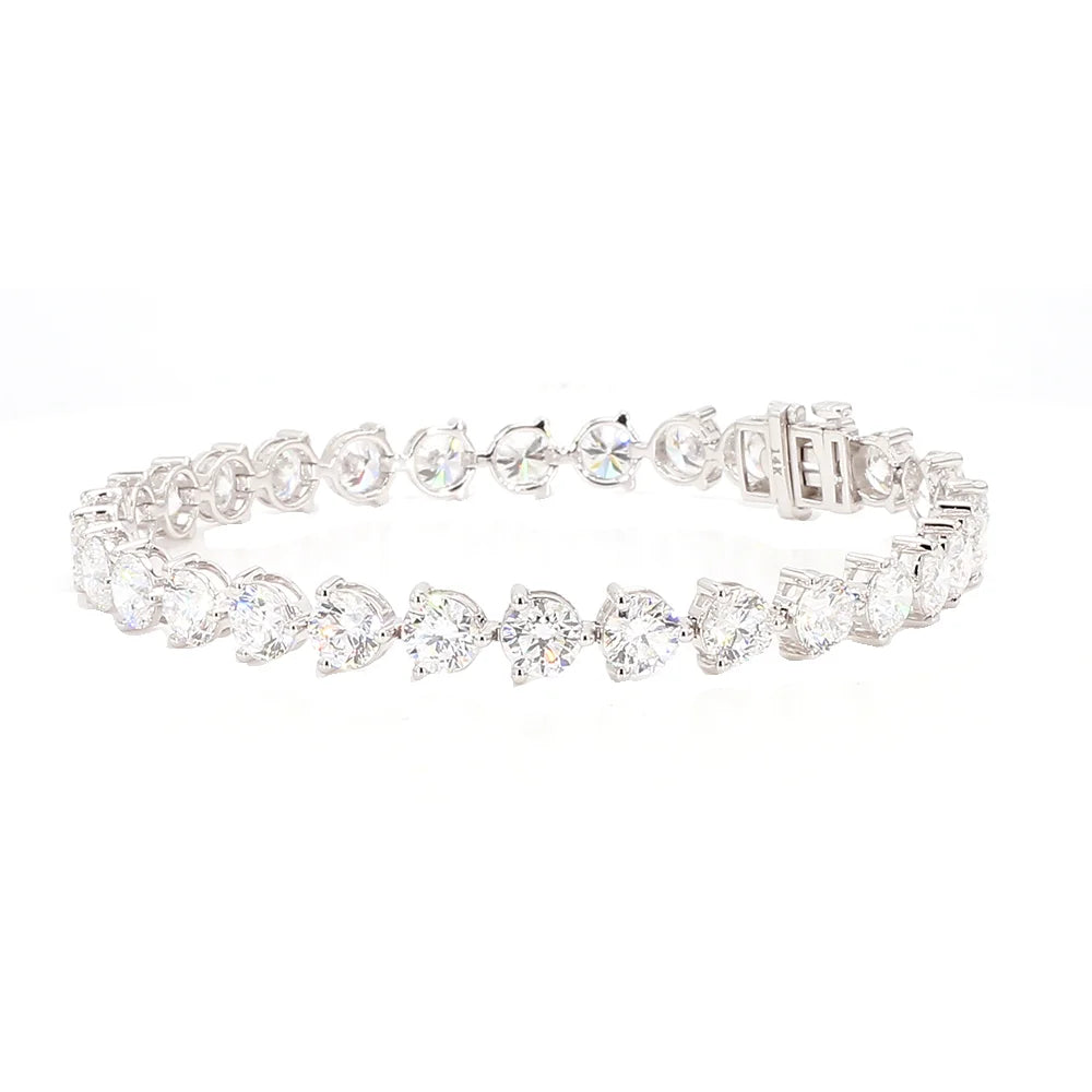 A silver tennis bracelet featuring a continuous row of clear heart-shaped and round-cut gemstones, displayed on a clean white background.