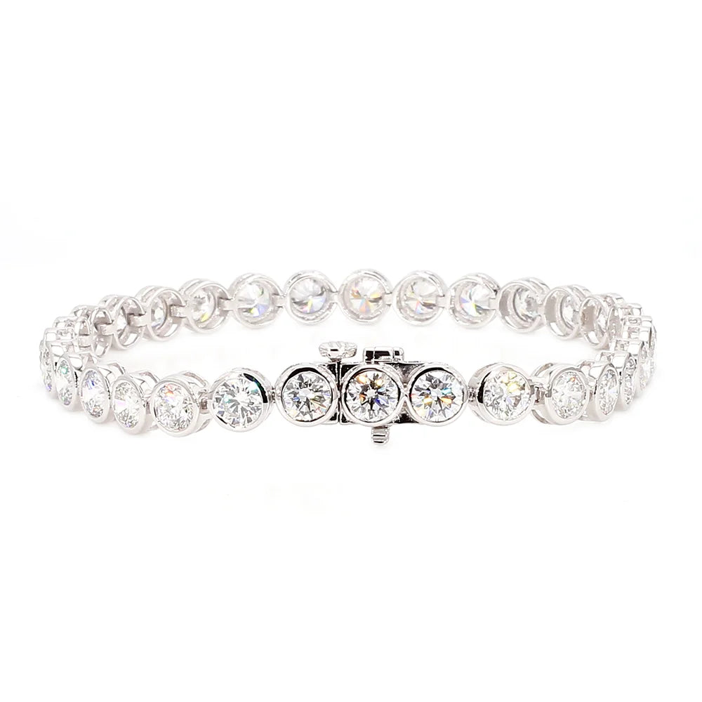 A silver-toned tennis bracelet featuring round brilliant-cut clear stones in a continuous link design, with a central clasp, shown on a plain white background.